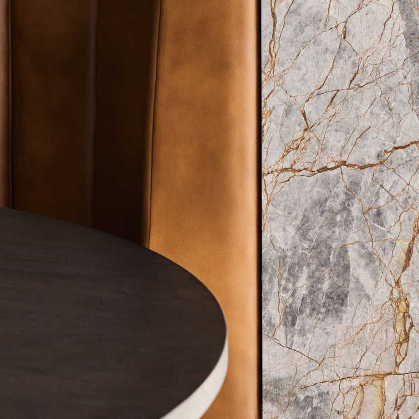 Close-up of a marble and leather surface with a dark brown leather chair.